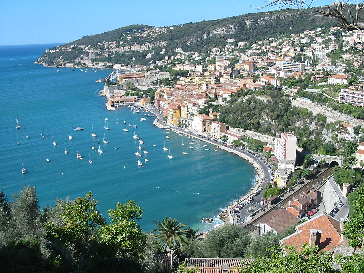 La rade de Villefranche-sur-Mer et ses maisons ocre dévalant vers la mer turquoise, paysage emblématique des Corniches de la Côte d'Azur