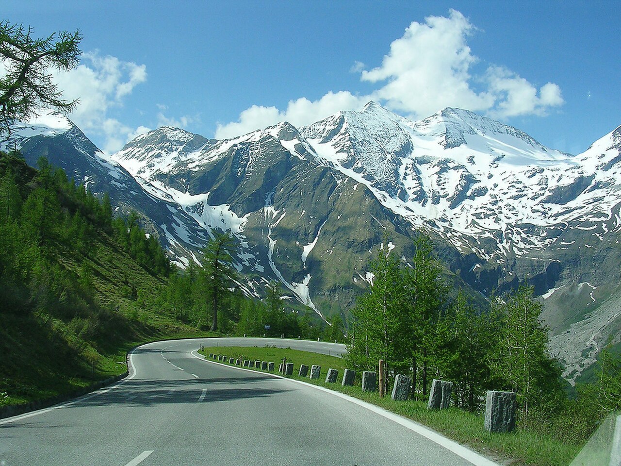 La Grossglockner Hochalpenstrasse serpentant en virages dans les Hautes Alpes autrichiennes, face aux sommets enneigés