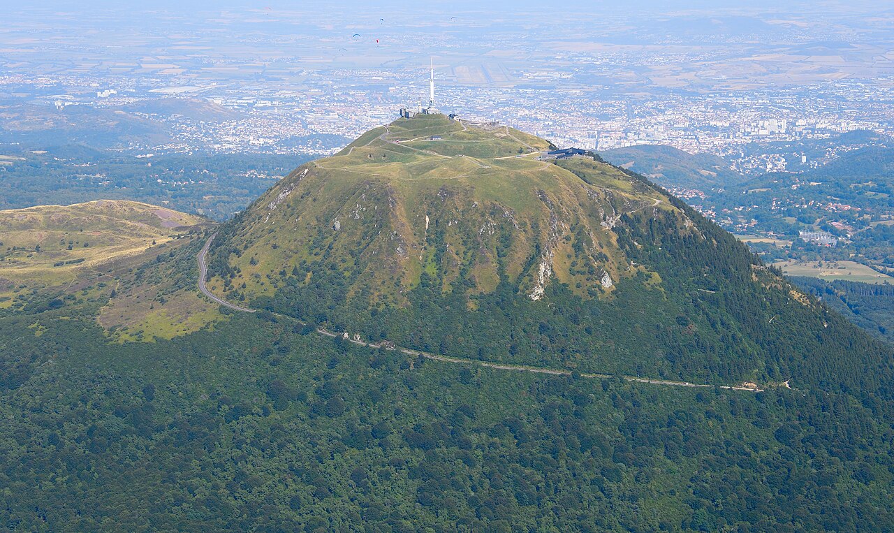 Vue aérienne du puy de Dôme et de la chaîne des Puys en Auvergne, volcans endormis couverts de forêt et de prairies